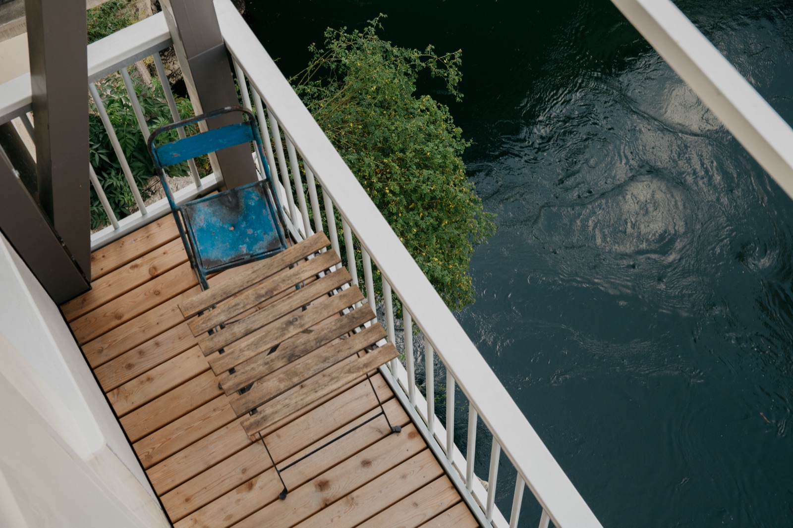 Stuhl auf dem Balkon über dem Fluss